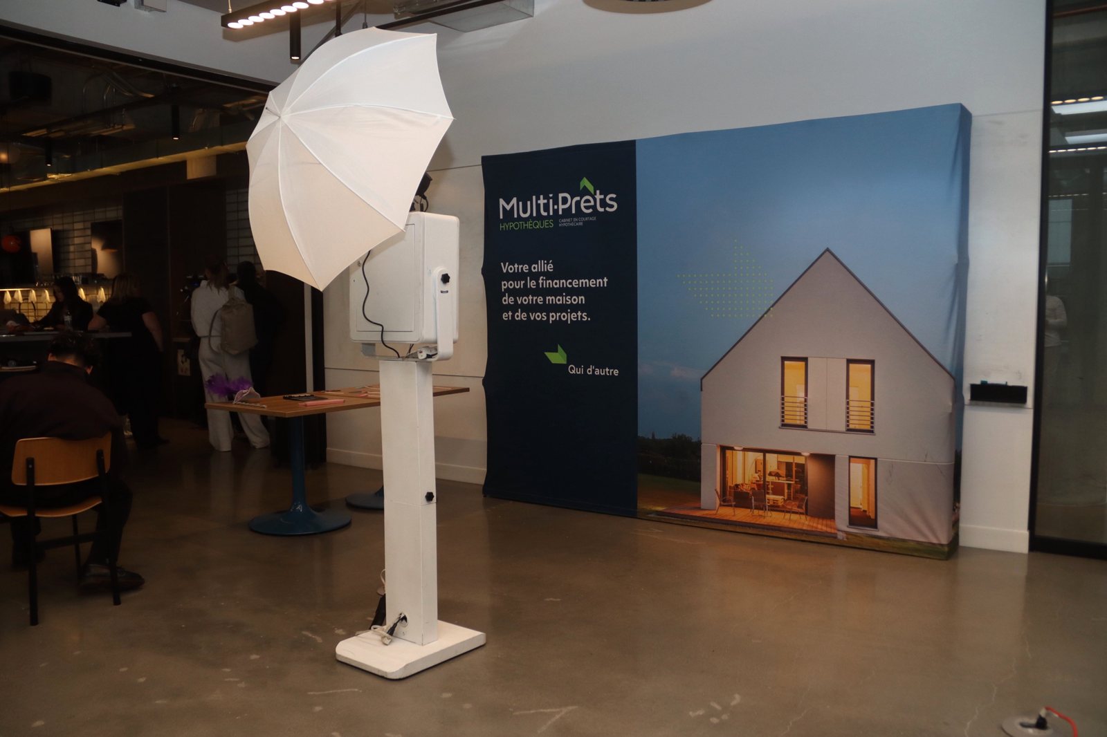 Photobooth installé dans les bureaux d’une entreprise, devant un fond à son image